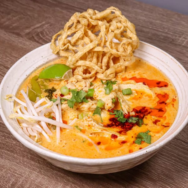 NUA Thai's Khao Soi with crispy noodles, chicken, bean sprouts, lime, and chili oil.