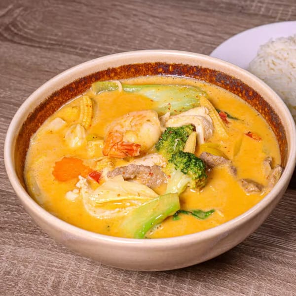 NUA Thai red curry with shrimp, chicken, beef, broccoli, baby corn, and other vegetables.